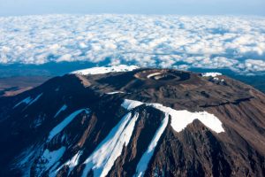 Best Tour Operator for Safari Tanzania – Aerial view of Mount Kilimanjaro summit above the clouds during trekking expedition